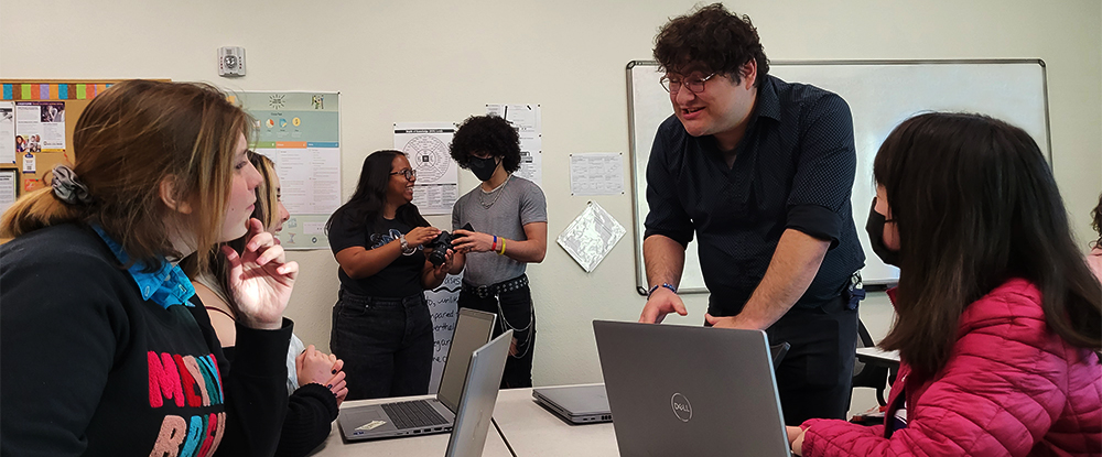 Students discussing work at computers