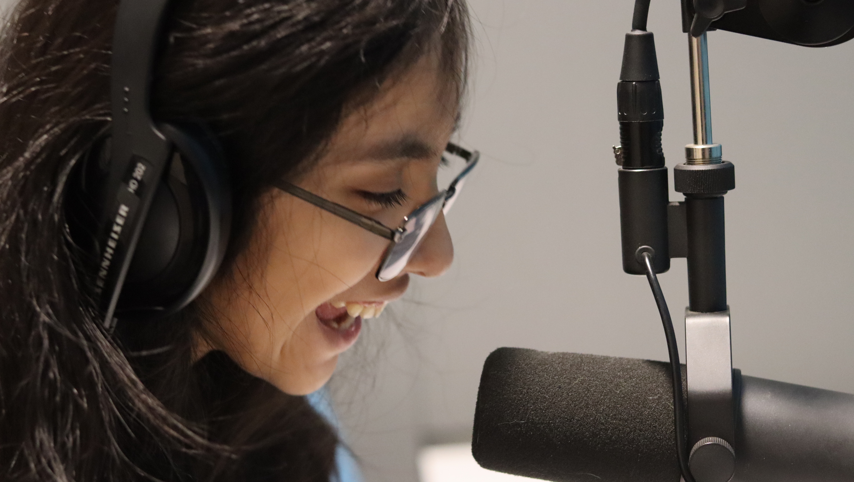 Closeup of girl speaking into a microphone.