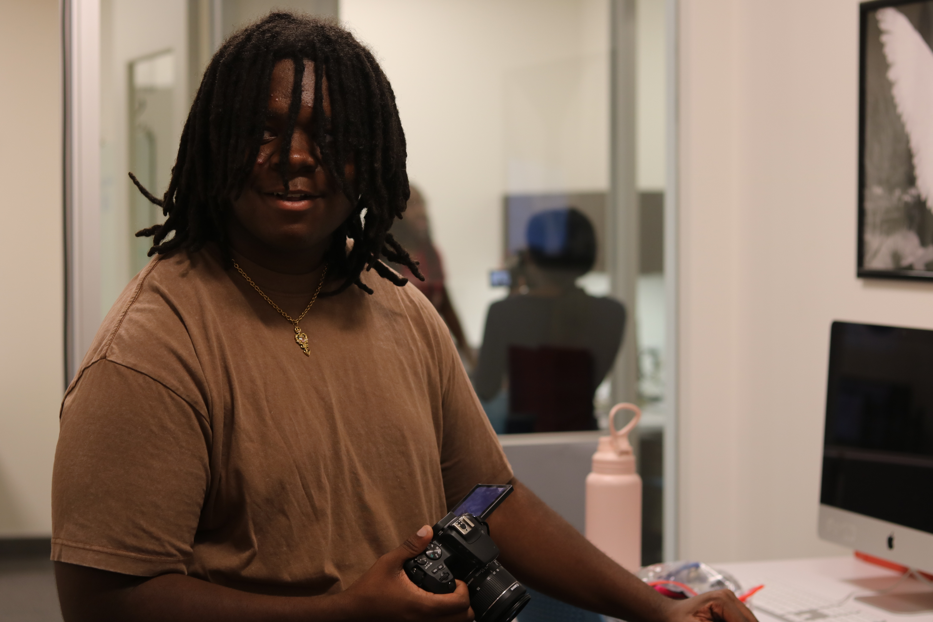 a SPOT student holding a camera in the classroom.