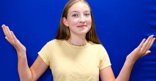 photo of spot 127 student Cara in front of a blue screen